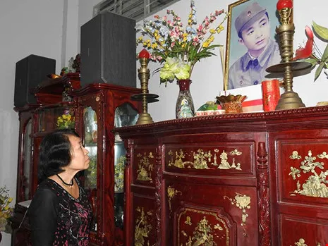 Bà Nguyễn Thị Mai, vợ ông Lữ Anh Dồi bên di ảnh của chồng. Ảnh: T.VŨ