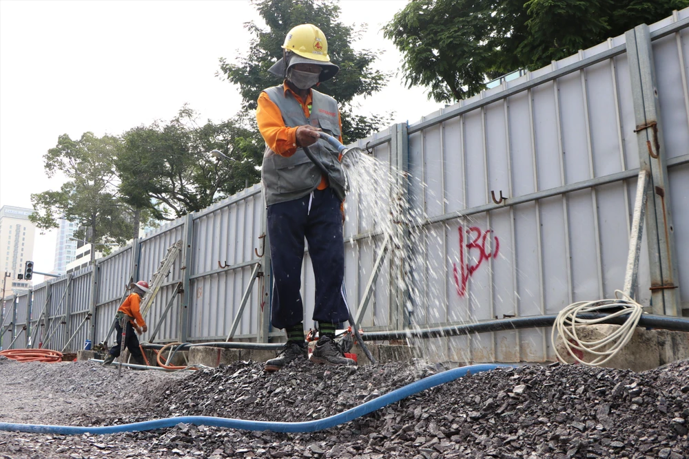 Các công nhân tưới nước, đẩy nhanh tiến độ. Ảnh: HT.