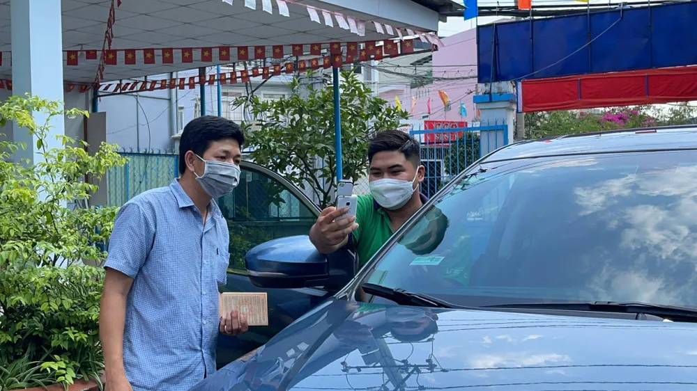 Người dân dán thẻ thu phí không dừng của VETC. Ảnh: ĐÀO TRANG.