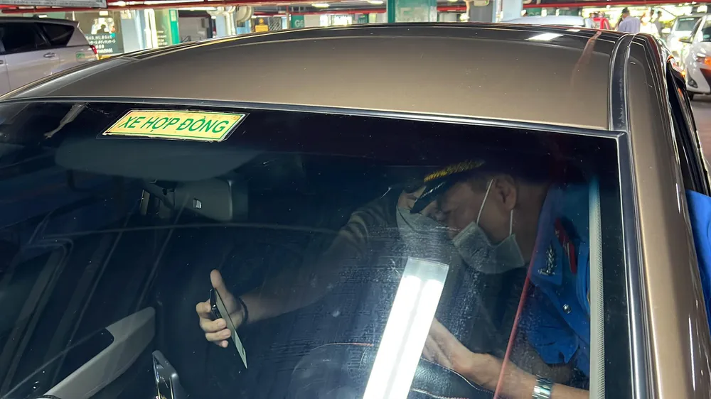 Thanh tra giao thông làm việc với khách hàng trong việc đặt chuyến đi qua app. Ảnh: ĐT. Thanh tra giao thông làm việc với khách hàng trong việc đặt chuyến đi qua app. Ảnh: ĐT.