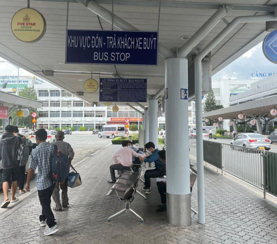 Nhiều hành khách ngồi chờ ở khu vực xe buýt.