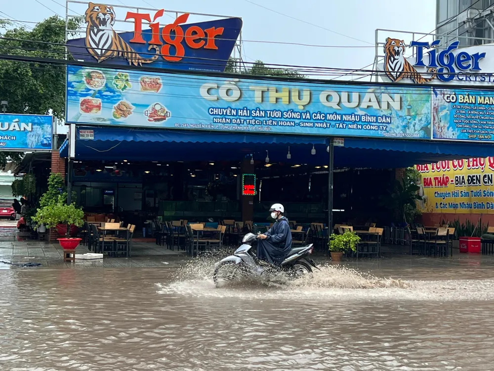 Người dân phải co chân lại để né ướt.