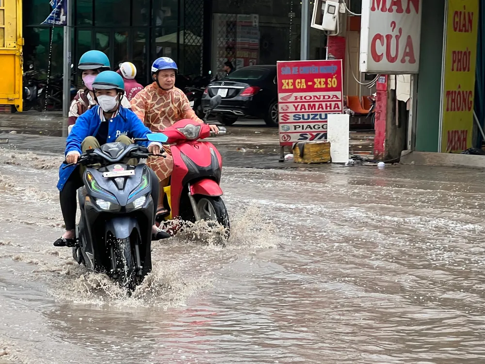 Người dân di chuyển qua đoạn đường ngập nước.