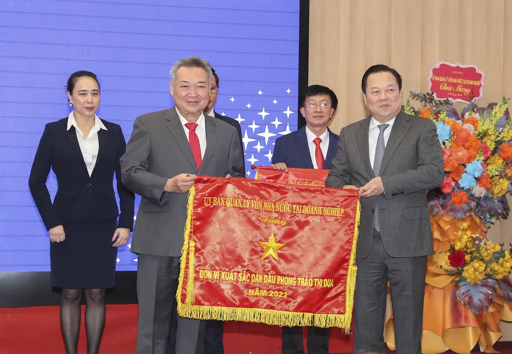 Chủ tịch Hội đồng thành viên EVNHCMC Phạm Quốc Bảo (bên trái) thay mặt đơn vị đón nhận Cờ “Đơn vị xuất sắc dẫn đầu phong trào thi đua năm 2022” do Ủy ban Quản lý vốn nhà nước tại doanh nghiệp trao tặng. Ảnh: Ngọc Tuấn.