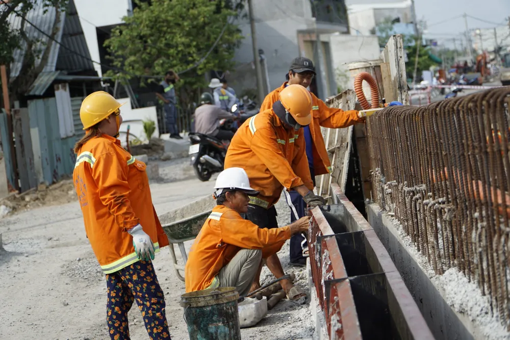 Công nhân đang thi công ngày đêm dưới cái nóng oi bức, tất cả với quyết tâm đưa dự án về đích đúng tiến độ. Ảnh: ĐÀO TRANG