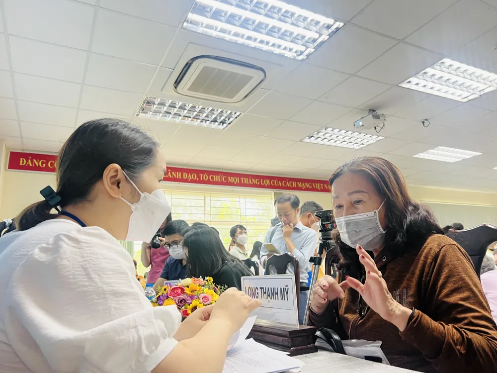 Cán bộ Ban bồi thường giải phóng mặt bằng, TP Thủ Đức hướng dẫn tỉ mỉ cho các hộ dân trong việc làm thủ tục, nhận bồi thường. Ảnh: ĐÀO TRANG