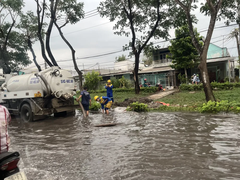 Tới 17 giờ chiều, nước trên đường Trần Văn Giàu vẫn chưa rút. Ảnh: ĐÀO TRANG