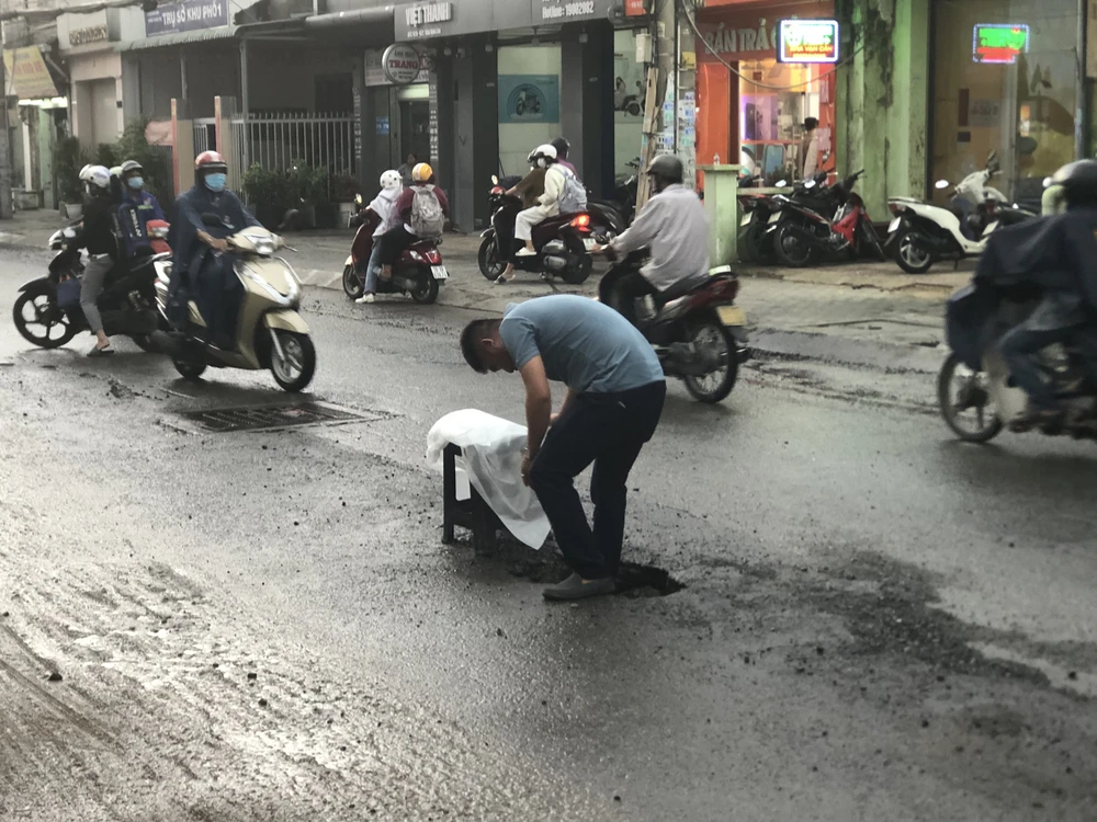 Có những đoạn trên đường Kha Vạn Cân xuất hiện các hố sâu. Người dân đã sử dụng ghế để cảnh báo nguy hiểm cho người tham gia giao thông.