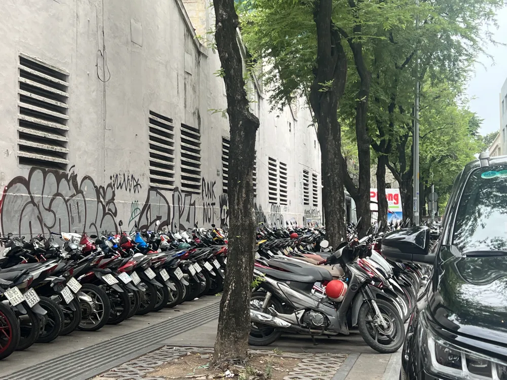 Toàn bộ vỉa hè được dùng để trông giữ xe, ô tô cũng đậu dưới lòng đường. Ảnh: ĐÀO TRANG