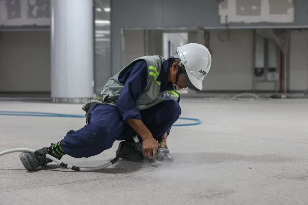 Công nhân đang chà gạch ở ga trung tâm Bến Thành, tuyến metro số 1. Ảnh: MAUR