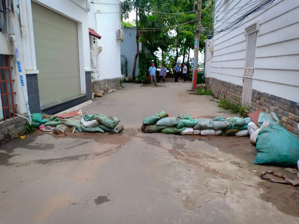 Hẻm 9 đường Nguyễn Văn Hưởng - người dân phải &quot;làm đê&quot; ngăn nước tràn vào nhà. Ảnh: CTV