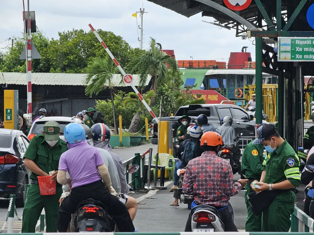 Các phương tiện xếp hàng dài để chờ lên phà.