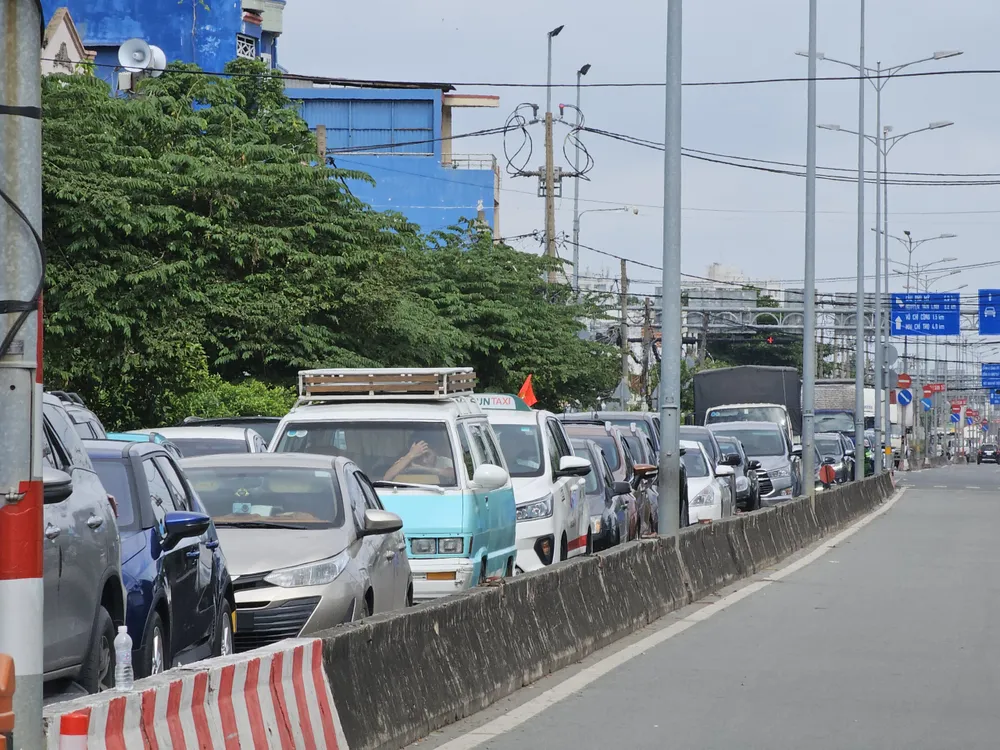 Hàng loạt ô tô xếp hàng dài để chờ vào phà.
