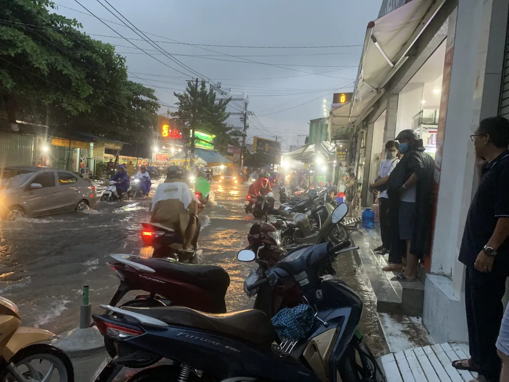 Người dân chờ nước rút mới tiếp tục di chuyển, có xe bị ngập nửa bánh xe. ngap