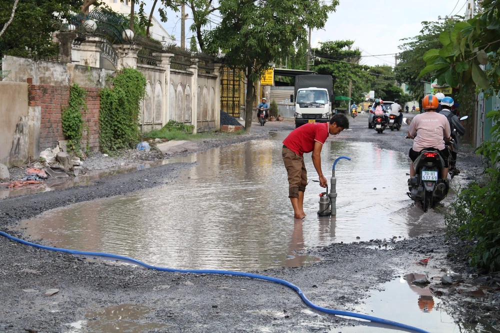 Người dân phải dùng máy bơm để hút nước ra ngoài. duong-xuong-cap