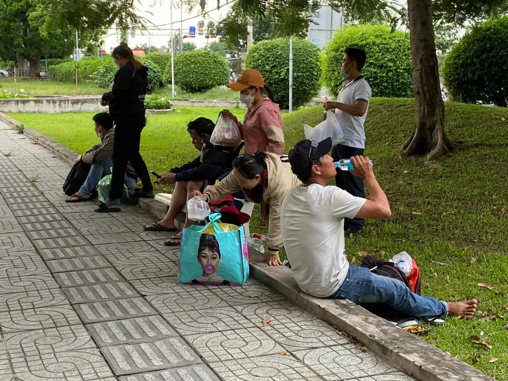 Hành khách tranh thủ ăn uống khi đợi xe. ẢNH: CÁT TƯỜNG ben-coc