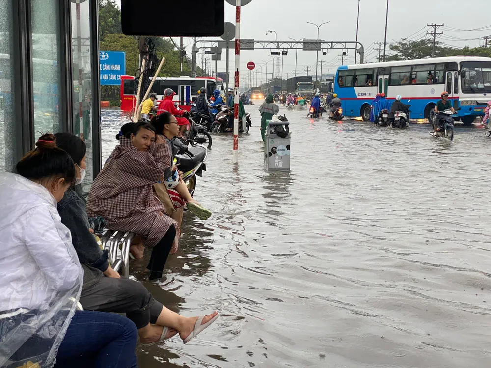 Người dân ngồi trên trạm xe buýt chờ nước rút. z4810767551953_0f6e0b2005add6dd8c2dd466086a4326.jpg