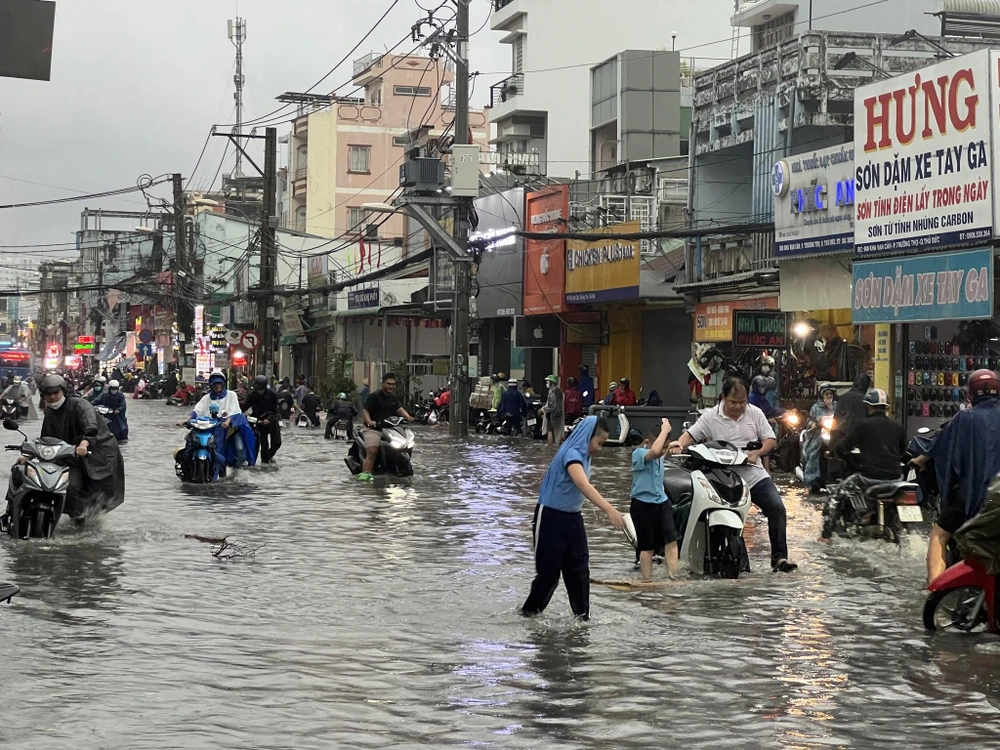 Người dân gặp khó khăn khi di chuyển trên đường Kha Vạn Cân. Đường Kha Vạn Cân, phường Linh Đông, TP Thủ Đức đang bị ngập nước