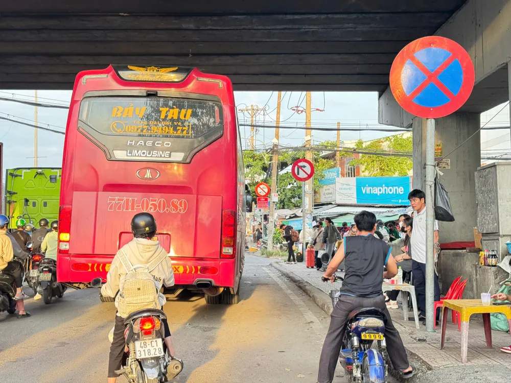 Xe khách đón trả khách dưới dạ cầu, trên quốc lộ 1 dù đã có biển cấm. Người dân bắt đầu nghỉ lễ 2-9, các tuyến đường ở TP.HCM đông đúc