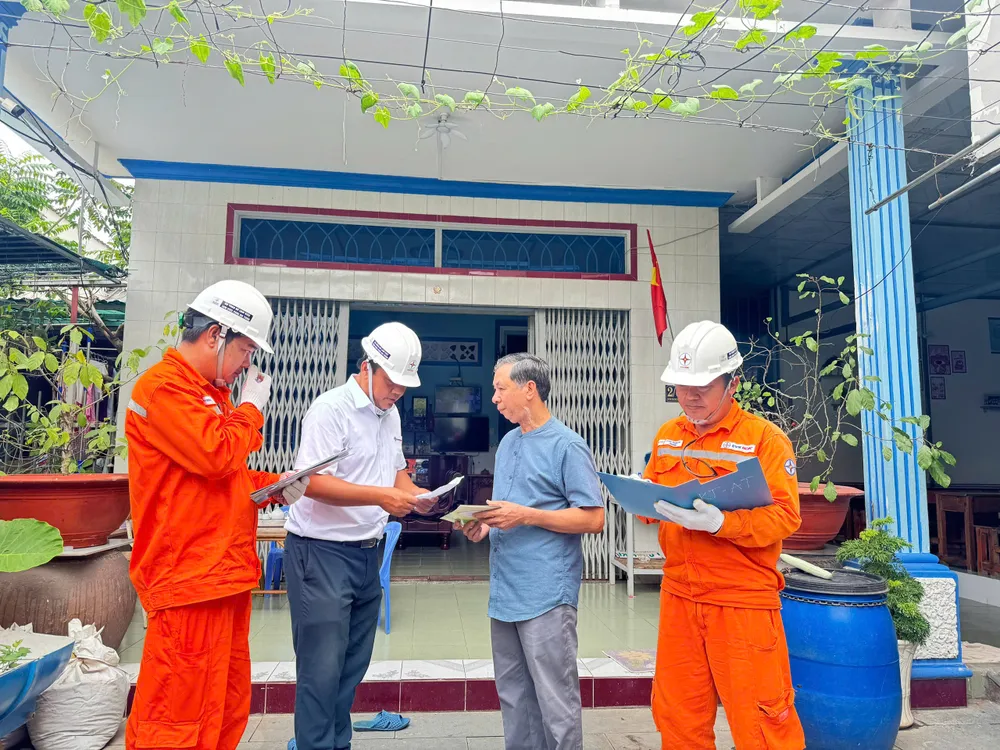 Các công nhân Điện lực TP.HCM tuyên truyền người dân sử dụng điện an toàn mùa mưa bão. Ảnh: ĐÀO TRANG Điện lực TP.HCM 13.jpg