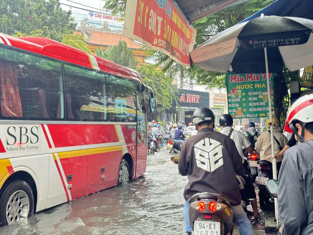 Nhiều người dân phải chạy lên vỉa hè để vượt qua đoạn ngập. duong-kha-van-can