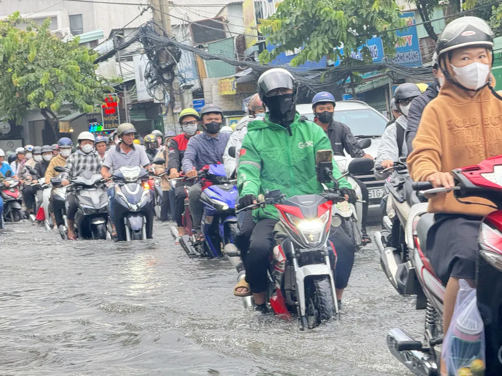 Người dân chật vật vượt qua tuyến đường ngập nước. duong-kha-van-can