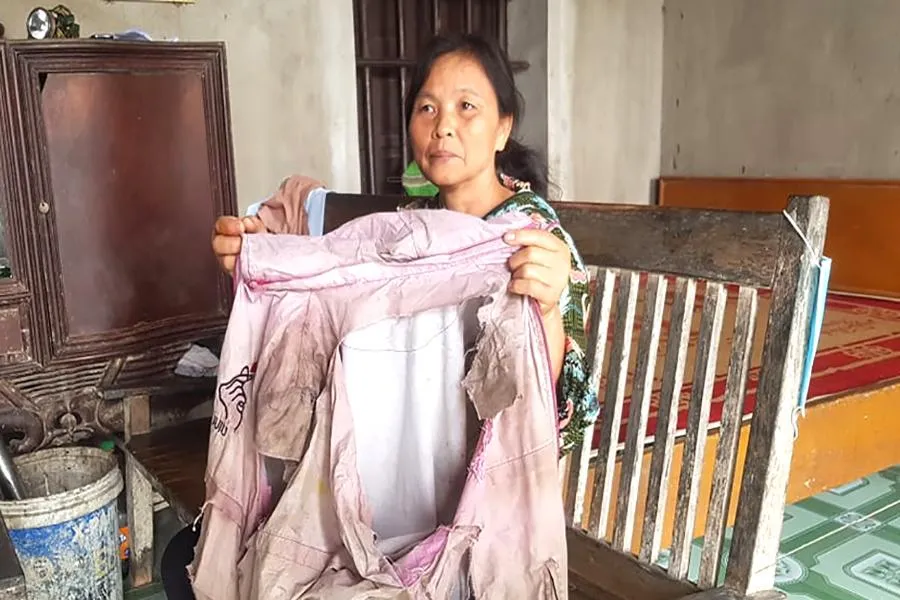 Chị Hẹn kể về chiếc áo bị rách sau nhiều giờ lội suối đi xuyên rừng để tìm lối ra. Ảnh: Đ.T