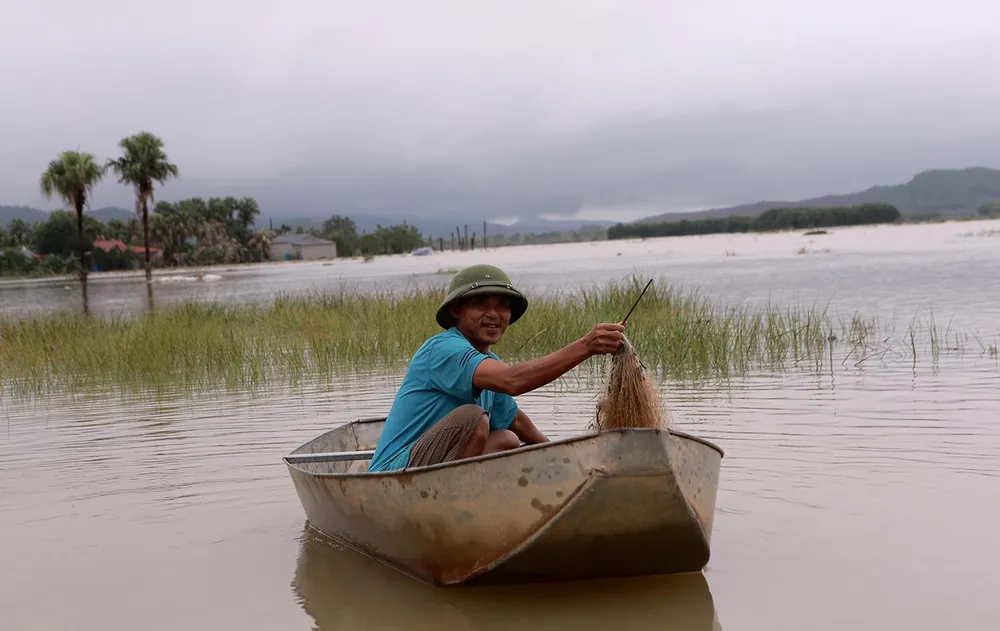 Nước lũ về một người dân tranh thủ đi thả lưới để cải thiện bữa ăn. Ảnh: ĐẶNG TRUNG