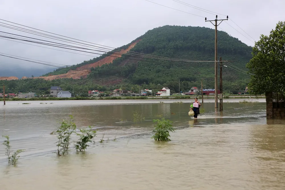 Một người dân địa phương trở về nhà mang theo miến gạo thực phẩm, cá khô tích trữ vì lũ có thể gây cô lập nhiều ngày. Ảnh: ĐẶNG TRUNG