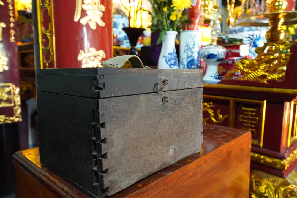 Ngay bên bàn thờ Mẹ Tơm, rương gỗ lưu giữ bộ đồ nghề cắt tóc của hai người con Mẹ Tơm là Vũ Văn Sồ và Vũ Đức Hậu. Ảnh: ĐẶNG TRUNG