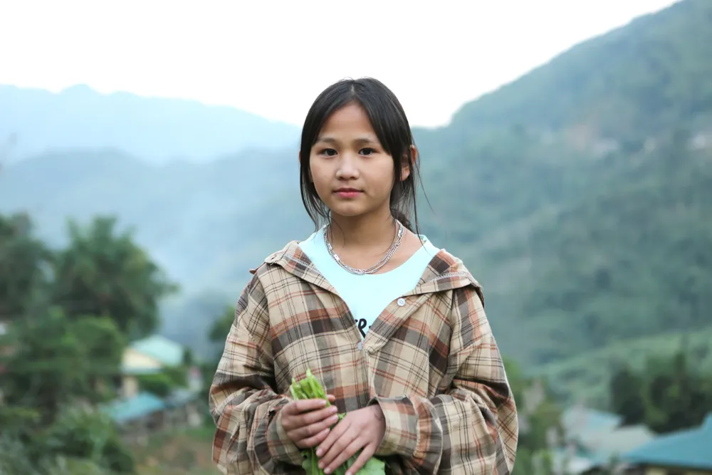 Học sinh Lý Thị Dụ trong ngày thu hoạch rau xanh. Ảnh: ĐẶNG TRUNG