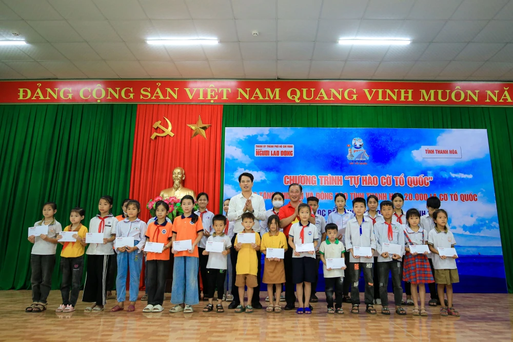 Ông Đào Xuân Yên Trưởng ban Tuyên giáo Tỉnh ủy Thanh Hóa cùng lãnh đạo báo Người Lao Động trao quà cho học sinh nghèo ở thành phố Sầm Sơn. Ảnh: TUẤN MINH