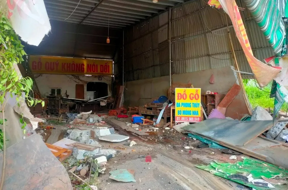 Xưởng đồ gỗ bị biến dạng tường, hỏng cửa sau khi cả hai xe khác lẫn xe tải đâm vào. Ảnh: ĐẶNG TRUNG Xưởng đồ gỗ bị biến dạng tường, hỏng cửa sau khi cả hai xe khác lẫn xe tải đâm vào. Ảnh: ĐẶNG TRUNG