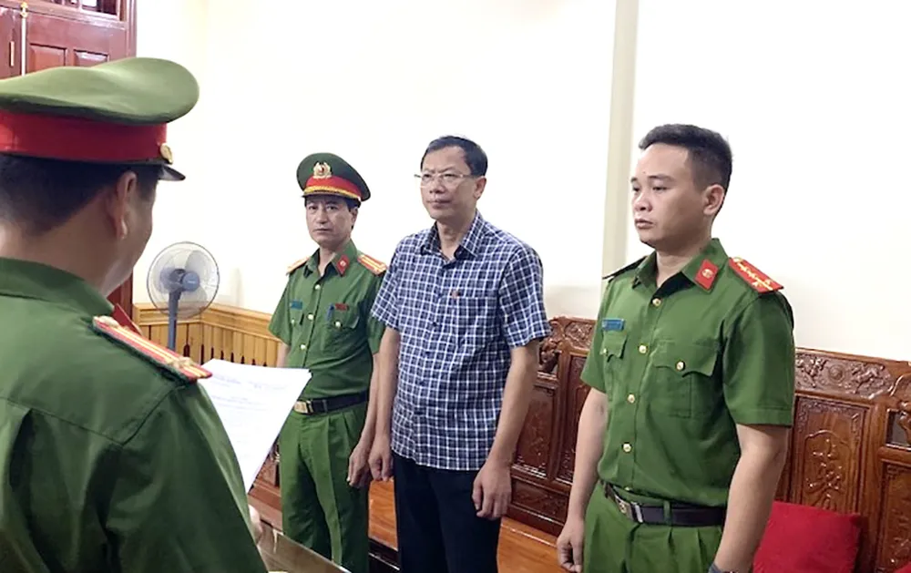 Ông Nguyễn Văn Hùng Hiệu trưởng Trường Cao đẳng Công nghiệp Thanh Hóa bị khởi tố, bắt tạm giam để điều tra về tội lợi dụng chức vụ, quyền hạn trong khi thi hành công vụ. Ảnh: ĐH Công an tống đạt quyết định khởi tố hiệu trưởng Trường Cao đẳng Công nghiệp Thanh Hóa