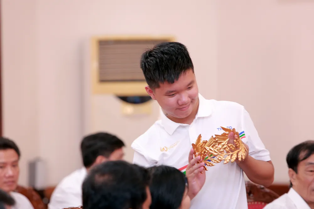 Khoảnh khắc em Lê Xuân Mạnh ngắm nhìn vòng nguyệt quế tại buổi tuyên dương. Ảnh: ĐẶNG TRUNG Lê-Xuân-Mạnh-Đường-Lên-Đỉnh-Olympia-1.JPG