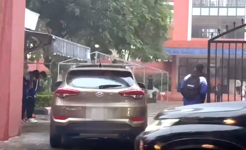 Hình ảnh hai học sinh cúi đầu chào thầy cô giữa trời mưa giá rét tại cổng Trường THCS Trần Mai Ninh, TP Thanh Hóa.