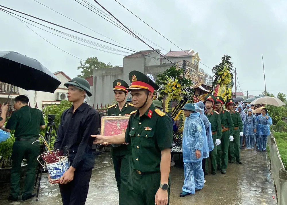Đồng đội, người thân, hàng xóm tiễn biệt Đại úy Nguyễn Đình Khiêm. Ảnh: N.SỰ Dòng người tiễn biệt Đại úy Nguyễn Đình Khiêm hy sinh khi làm nhiệm vụ chống bão số 3 - 3.jpg