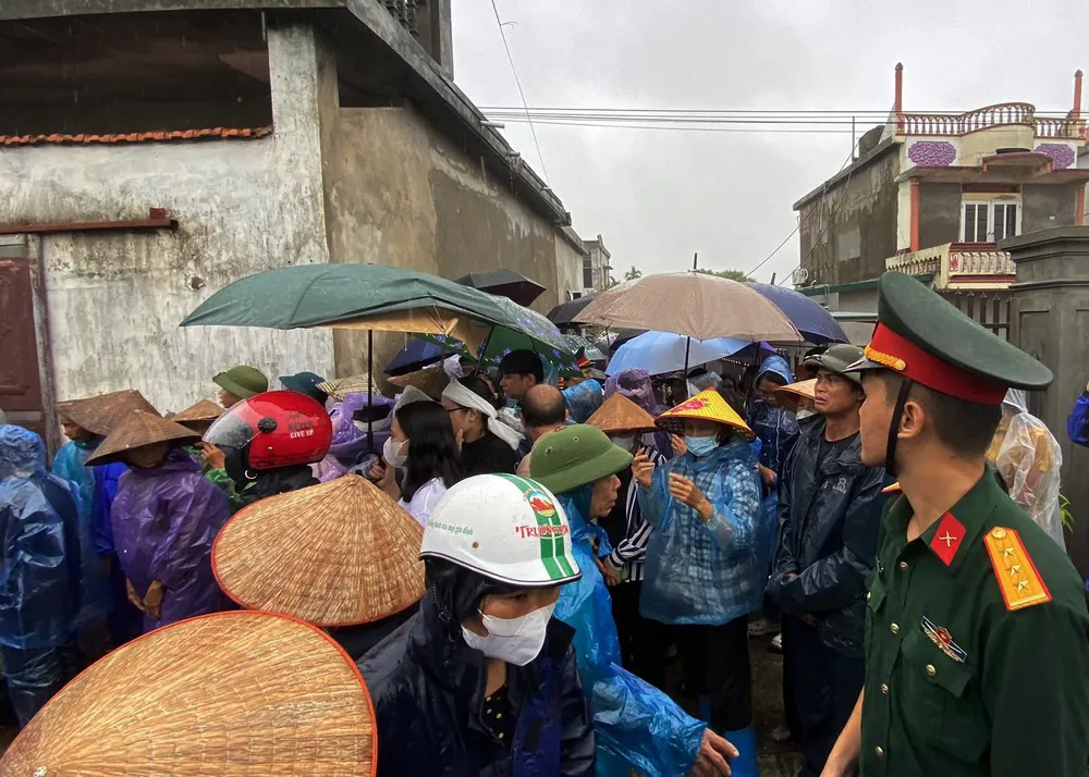 Hàng trăm người dân địa phương đội mưa tiễn đưa Đại úy Nguyễn Đình Khiêm hy sinh trong khi làm nhiệm vụ phòng chống bão số 3. Ảnh: N. SỰ Dòng người tiễn biệt Đại úy Nguyễn Đình Khiêm hy sinh khi làm nhiệm vụ chống bão số 3 - 4.jpg