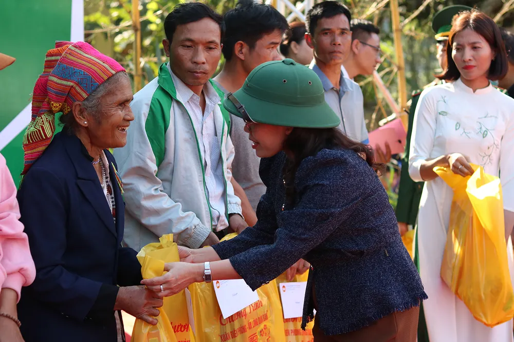 Bà Phạm Thị Hân, Chủ tịch Mặt trận Tổ quốc Việt Nam tỉnh Quảng Bình, trao quà Tết cho các hộ gia đình có hoàn cảnh khó khăn. Ảnh: BẢO THIÊN