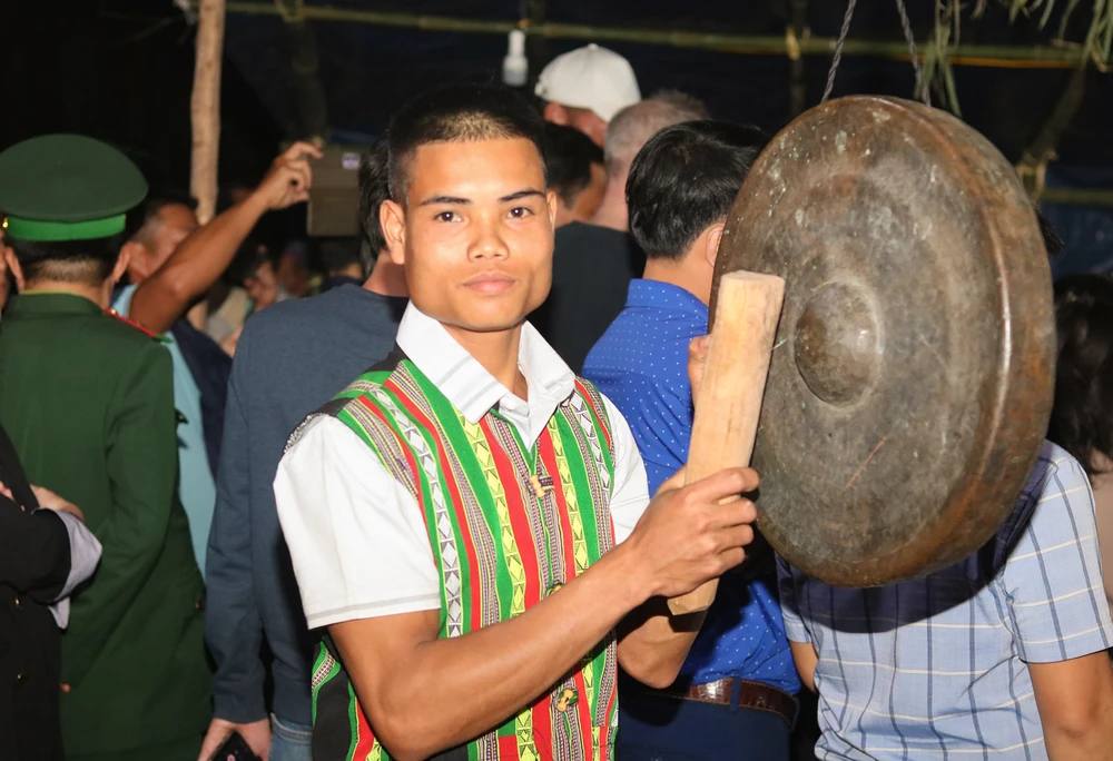 Nam thanh niên đồng bào Ma Coong đánh chiêng dẫn nhịp người đập trống. Ảnh: BẢO THIÊN