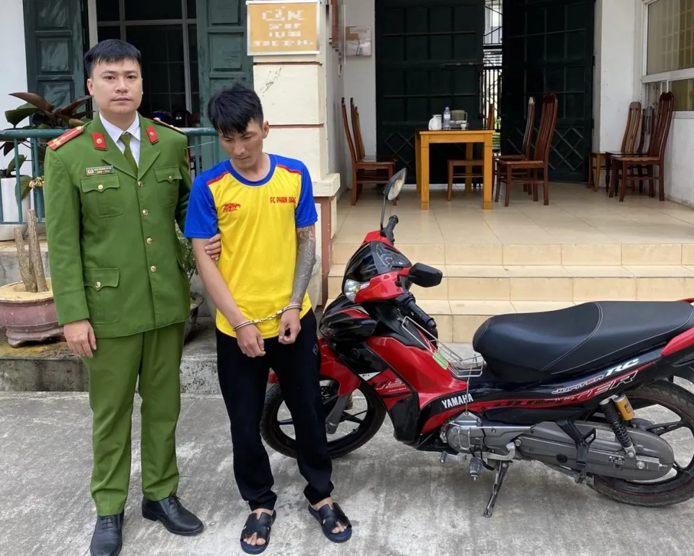 Trần Phan Hoàng cùng chiếc xe máy do Hoàng lấy trộm tại quán internet ở phường Bắc Lý. Ảnh:CA