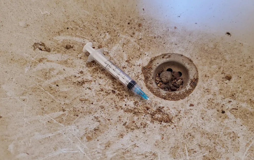 Những ống kim tiêm còn nguyên vết máu trong khuôn viên chợ Đồng Sơn. Ảnh: BẢO THIÊN