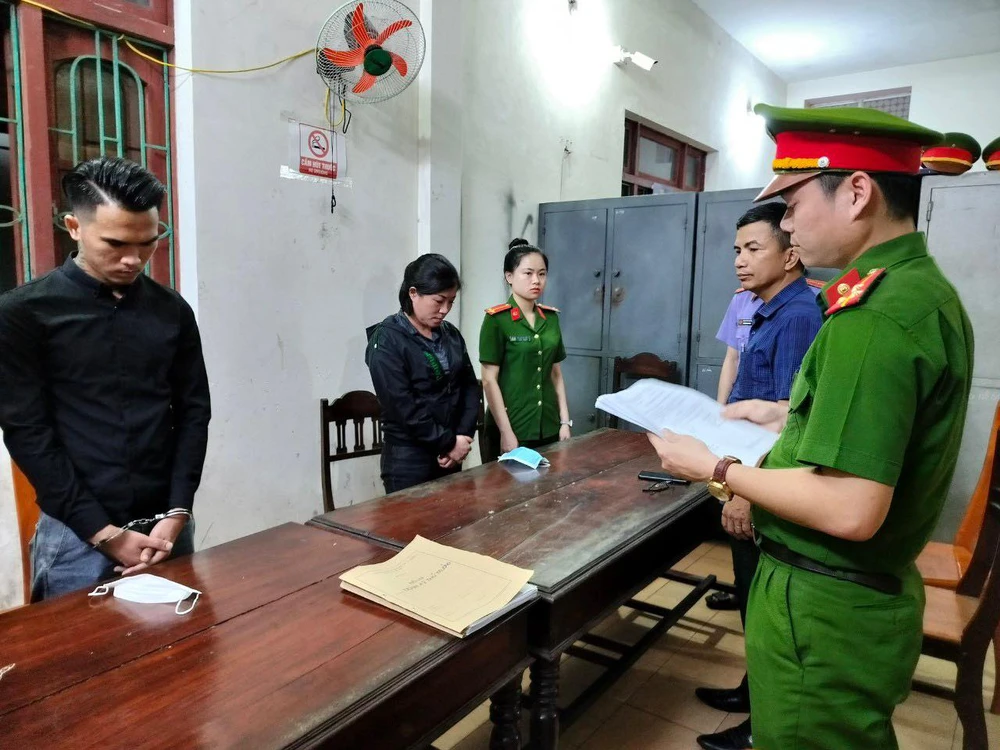 Cơ quan công an tống đạt các quyết định khởi tố đối với Luật và Hà. Ảnh: CA