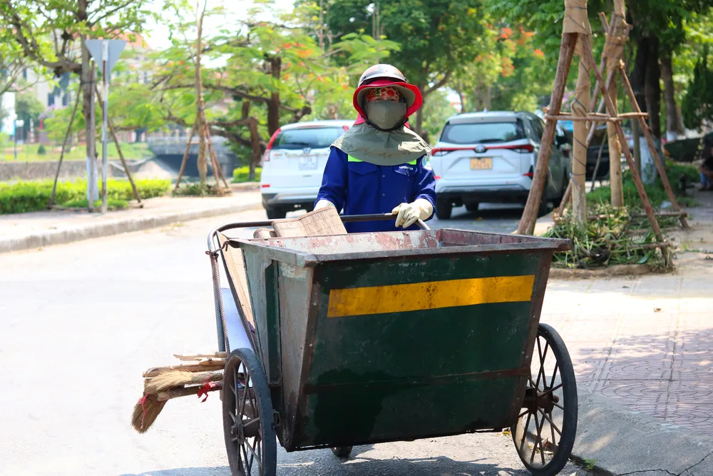 Chị Ngô Thị Bảy tất bật thu gom rác trên các tuyến đường. Ảnh: BẢO THIÊN Chị Ngô Thị Bảy tất bật thu gom rác trên các tuyến đường. Ảnh: BẢO THIÊN