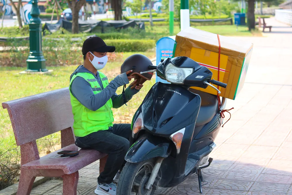 Anh Ngô Bình (shipper) tiếp tục công việc sau khoảng thời gian ngắn nghỉ ngơi. Ảnh: BẢO THIÊN Anh Ngô Bình (shipper) tiếp tục công việc sau khoảng thời gian ngắn nghỉ ngơi. Ảnh: BẢO THIÊN