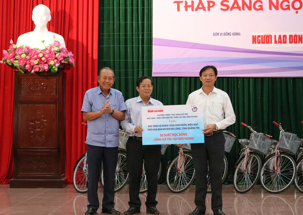 Lãnh đạo Báo Người Lao Động trao 50 suất học bổng cho các em học sinh có hoàn cảnh khó khăn trên địa bàn huyện Hải Lăng. Ảnh: BẢO THIÊN