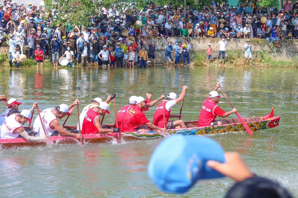 Người dân chen chân cổ vũ hai bên bờ sông Kiến Giang, huyện Lệ Thuỷ. Ảnh: BẢO THIÊN
