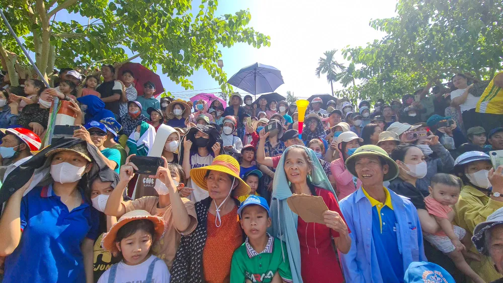Đông đảo người dân cổ vũ cho các thuyền bơi, đua trên sông. Ảnh: BẢO THIÊN