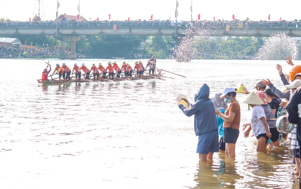 Các cổ động viên cổ vũ cho thuyền đua nữ. Ảnh: BẢO THIÊN