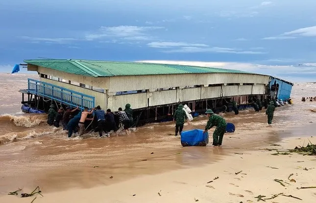 Các lực lượng chức năng và người dân tổ chức ứng cứu. Ảnh: H.NAM cuon-troi-nha-hang-noi-ra-bien-quang-binh.jpg